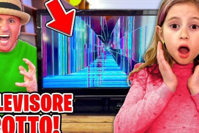 A surprised young girl and a frustrated man react to a cracked la televisione displaying colorful vertical lines.