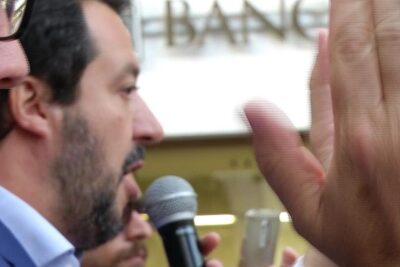 Close-up of a man speaking into a microphone at an event about ladozione gay