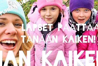 Smiling woman and four children in colorful winter hats and jackets capturing a happy family moment related to lapsen saaminen.