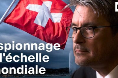 Close-up profile of a suited man and a waving Swiss flag with on-image text about lechelle mondiale espionage.