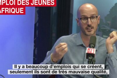 Radio speaker gesturing during a studio interview about lemploi jeunes and youth job quality.