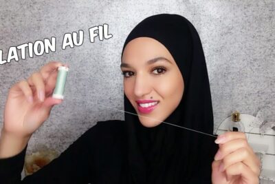 Smiling woman demonstrating lepilation pattes facial threading with a spool of thread
