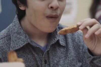 Person tasting a crispy snack, capturing lexperience sensorielle through taste and texture.