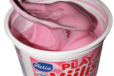 Pink strawberry yogurt in a tub with a spoon, showing lisattya sokeria on the label.