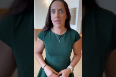 Concerned woman in a green dress standing indoors, evocative of livstidsdom fengsel and legal reporting.