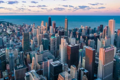Aerial view of dense skyscrapers and waterfront suggesting los principales argumentos en contra de vivir en la ciudad