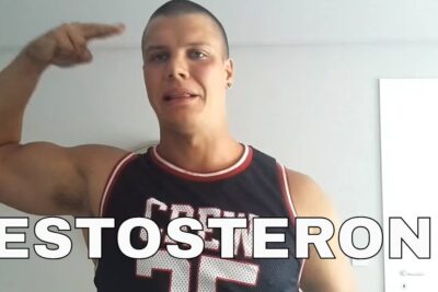 Muscular man flexing his arm indoors with a bold TESTOSTERONI text overlay and luonnollisten elintarvikkeiden 1