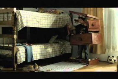Child partially hidden in dresser drawers beside bunk beds in a softly lit bedroom, maltrato infantil 5