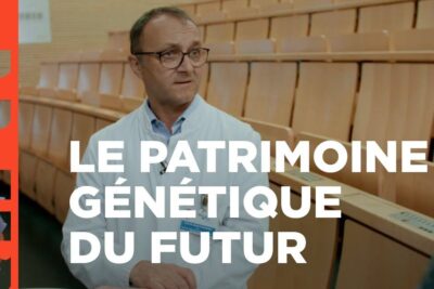 Man in lab coat speaking about manipulation genetique 1 in a lecture hall