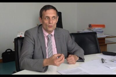Professional in a suit reviewing medicaments prescription paperwork at an office desk