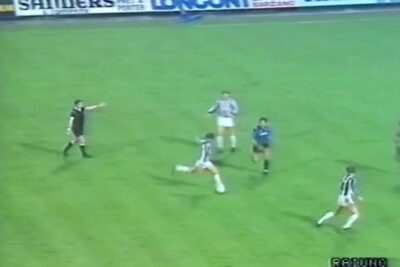 Midfield soccer moment with referee pointing and a player sliding on the grass, highlighting mika johtaa