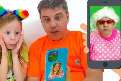 Adult man and young girl with rainbow headband look astonished at a bright blue smartphone showing a costumed face nat rlichen