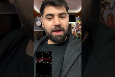 Close-up presenter discussing naturgas olja with a small trading chart visible in a vertical video