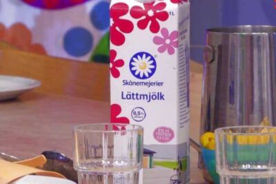 Carton of Skånemejerier Lättmjölk with two glasses and a stainless-steel jug on a kitchen table naturlig mat 3