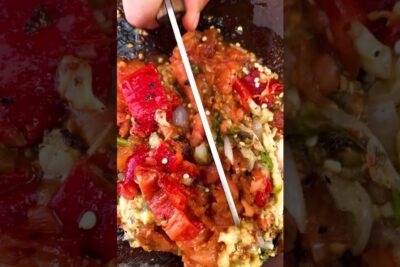 Chopped roasted red peppers, tomatoes and onions in a rustic bowl with a knife, naturlige fodevarer 1
