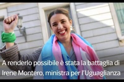 Smiling woman raising her fist wearing a pink and blue scarf celebrating nuova legge