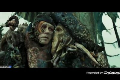 A grotesque, barnacle-covered sea captain with an octopus-like beard and tentacles evoking o kraken.