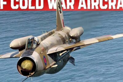 RAF Cold War-era aircraft flying low over the sea with camouflage and roundel, omfavne fiasko