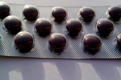 Close-up of a blister pack with glossy brown round tablets on tarkeaa 16