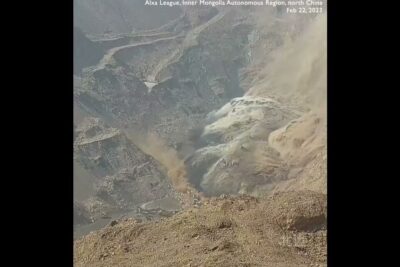 Terraced open-pit excavation with heavy dust plume demonstrating oppen gruvdrift