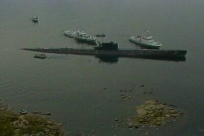 Submarine anchored near rocky islets with escort boats pa grund