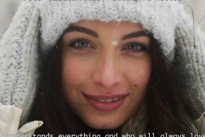 Smiling woman in gray knit hood with snowflakes pa nettet