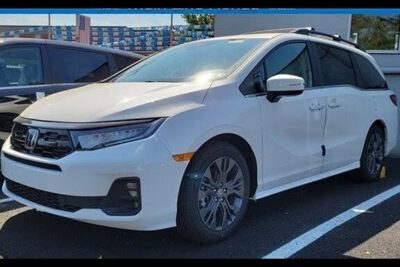White Honda minivan parked in a lot with alloy wheels and roof rails, pa odysseus.