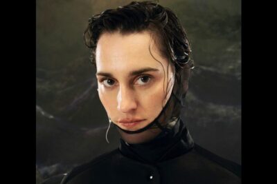 Close-up portrait of a model wearing a mesh headpiece and wet hair styled with peine mort 10.