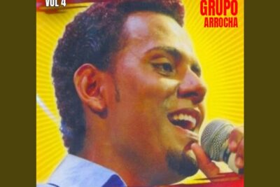 Close-up of a male singer smiling into a microphone on a vibrant yellow album cover featuring pena morte 17