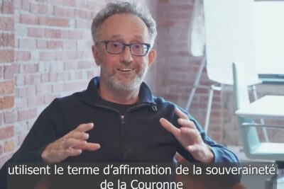 Middle-aged man with glasses gesturing during an interview with French subtitles about peuples autochtones.