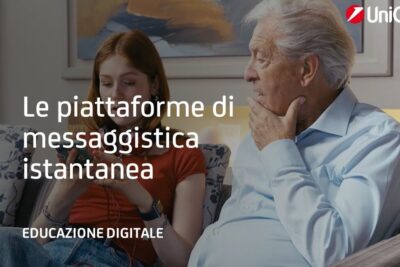 Young woman using a smartphone while an elderly man looks on, illustrating the use of piattaforme messaggistica in digital education.
