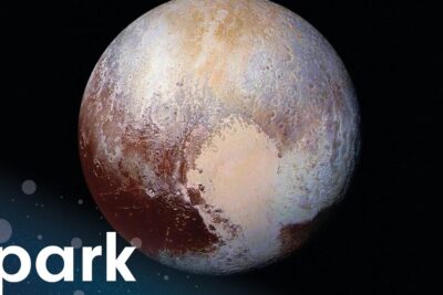 Close-up view of the pluto planet with textured surface, craters and a bright heart-shaped region.