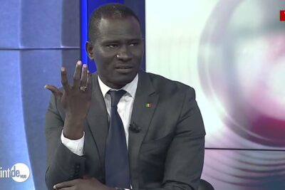 Suit-clad man gesturing during a studio interview discussing points vue