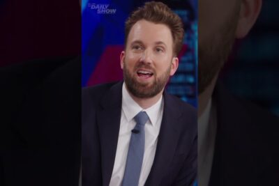 Bearded man in a suit speaking on a television talk show set during politiske debat 1.