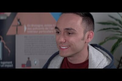 Smiling man in front of an informational poster about pollution environnementale 1 and environmental issues.