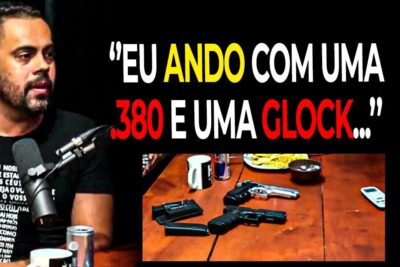 A man speaking into a microphone while multiple handguns and magazines lie on a table, referencing porte armas