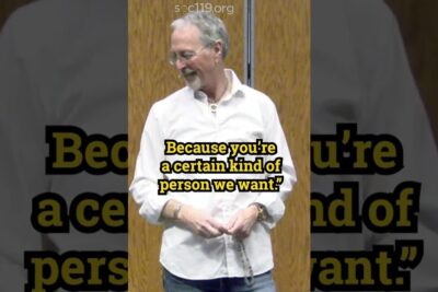 An older man wearing glasses and a white shirt smiles while a bold text overlay reads a quote, positiv diskriminering 1.