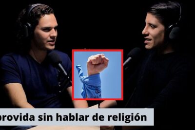 Two podcast hosts speaking into microphones with an inset image of a raised fist wrapped in a blue bandana, posturas pro vida 1