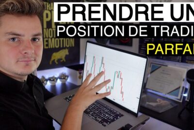 Young trader pointing at laptop candlestick chart to illustrate how to prendre position