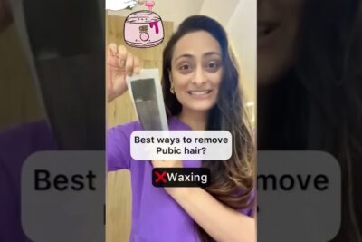 Woman holding a wax strip while demonstrating a pubic hair 1 removal method