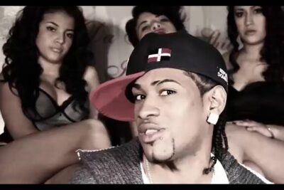 Close-up of a man in a tilted cap with three background models, punto vista centered on his expression.