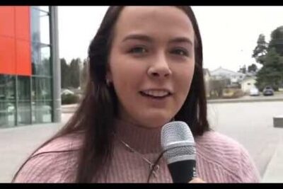 Young woman holding a microphone outdoors during a street interview for reproduktiv kloning 5