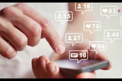 Hands tapping a smartphone screen with floating likes, comments, and follower notifications for reseau social 2.
