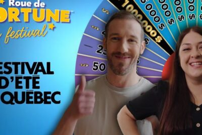 Two smiling presenters in front of a colorful prize wheel for roue fortune 1.