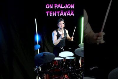 Drummer in a dark studio playing an energetic neon-lit drum set with ryostot voivat.