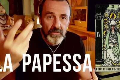 Bearded man gesturing next to a Rider-Waite High Priestess card labeled La Papessa with the phrase sacerdotessa tarocchi