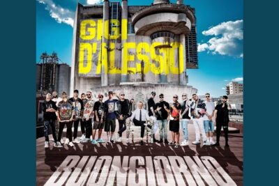 San valentino 1 promotional photo of a large group of men posing on a rooftop in front of a concrete building with bold yellow lettering
