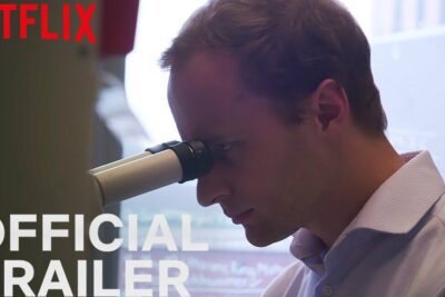 Scientist peering through a microscope in a laboratory still from selezione genetica 2.