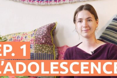 Young woman seated on a colorful sofa in a sens poil video thumbnail discussing adolescence.