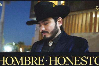 Man in a dark cowboy hat and bolo tie looking downward with a thoughtful expression, evoking ser honesto and reflective sincerity